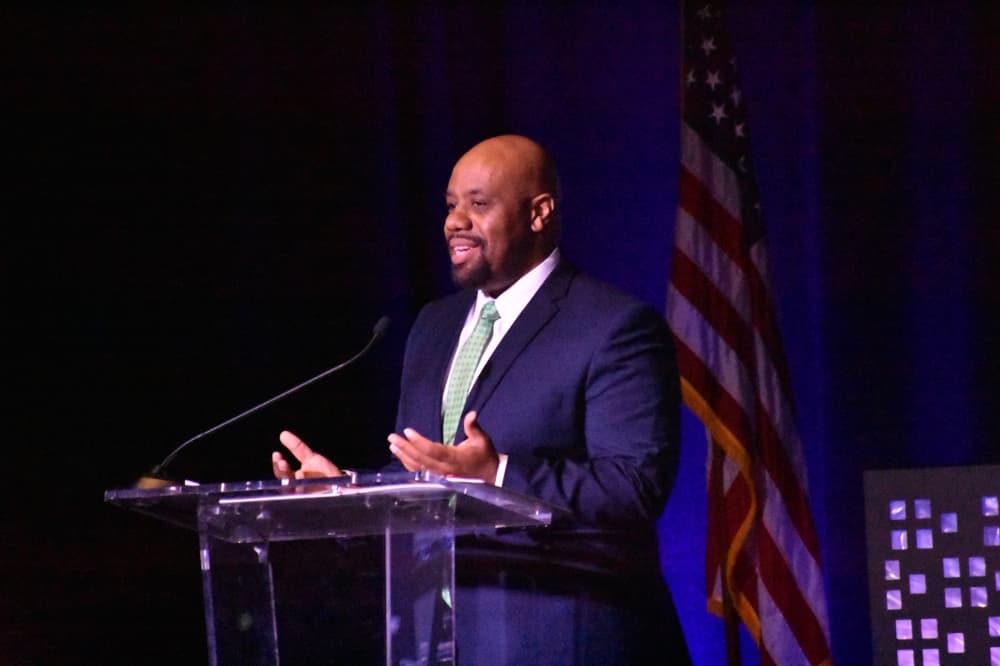 a man speaks at a podium