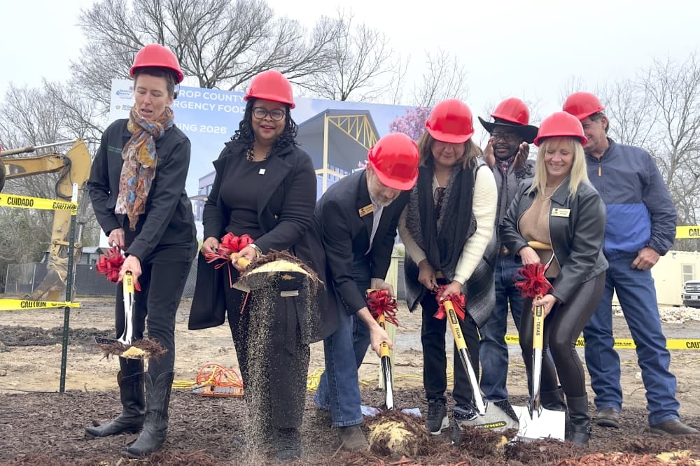 City, county and pantry officials shovel dirt.