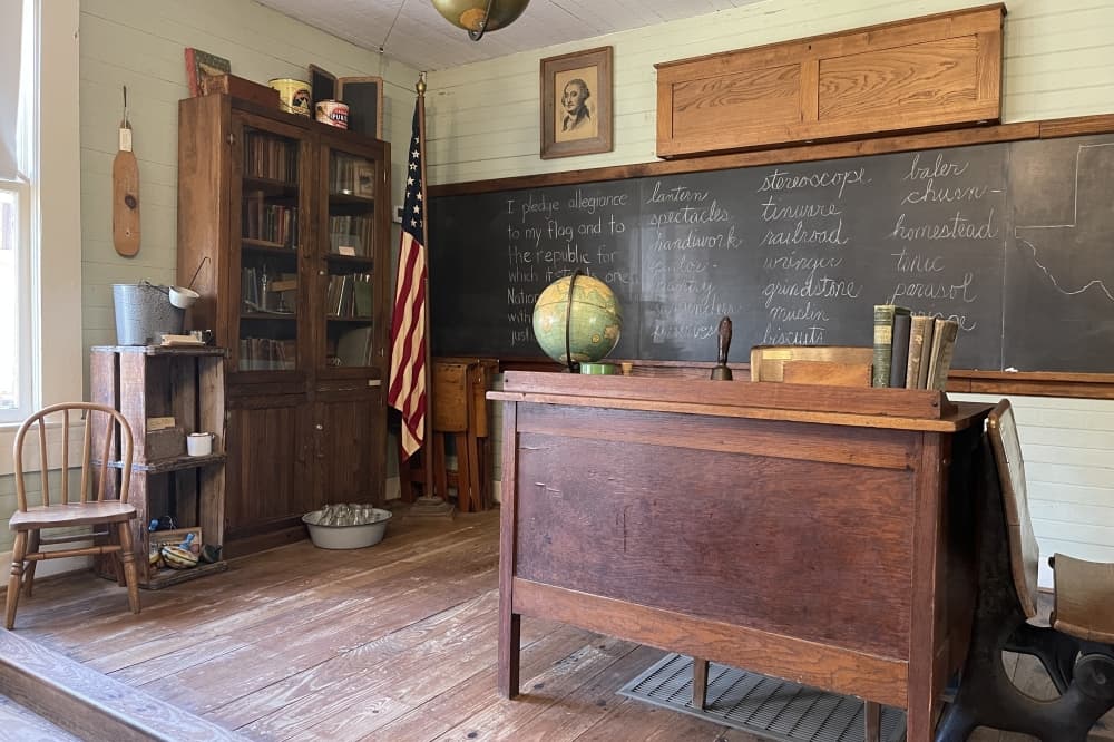 The teacher's desk in the old schoolhouse sits on a raised platform. The original platform had been removed after its years as a school ended. Workers rebuilt the platform using wood in the house that had been made into walls to separate the rooms. (James T. Norman/Community Impact)