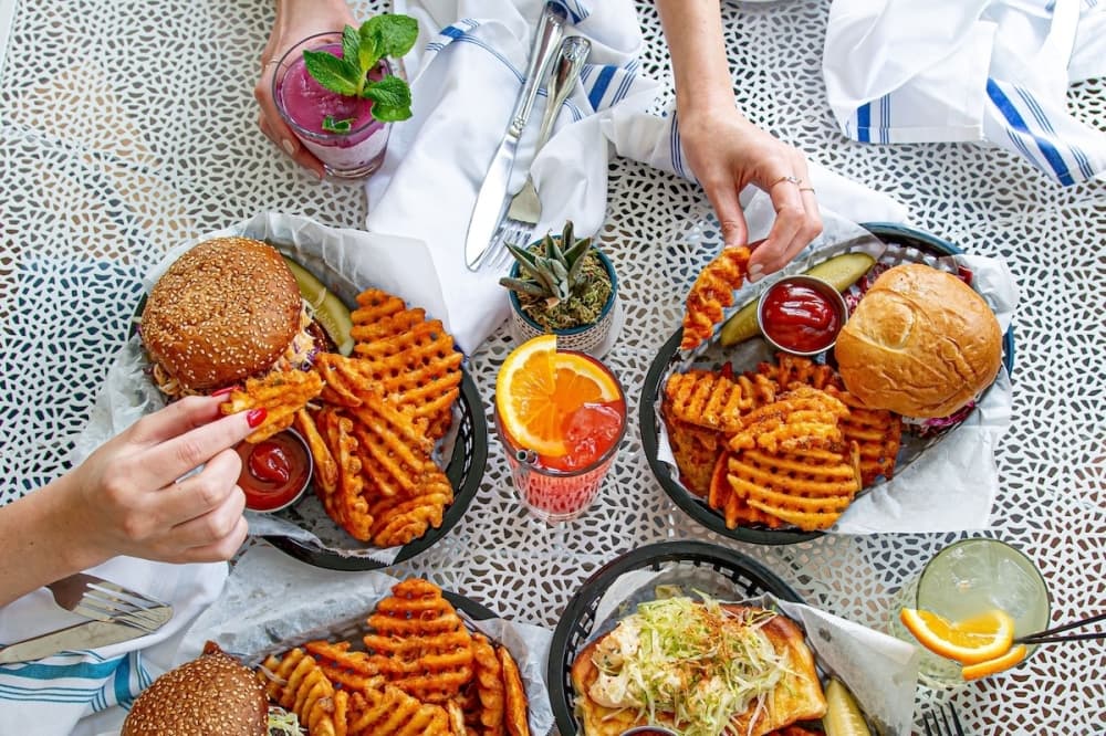 Burger, fries and cocktails on a table