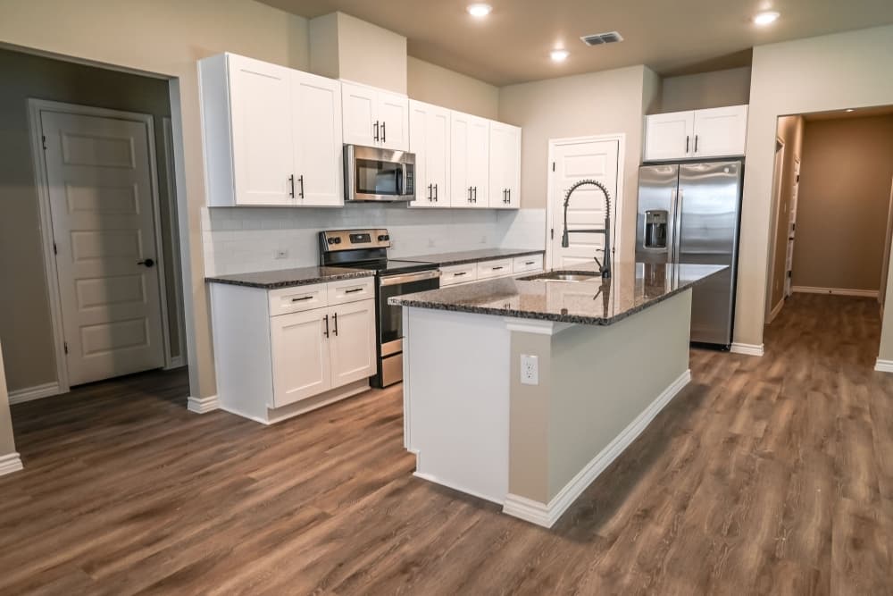 The interior of a BB Living rental home, which includes custom cabinetry, hardwood floors and granite countertops.