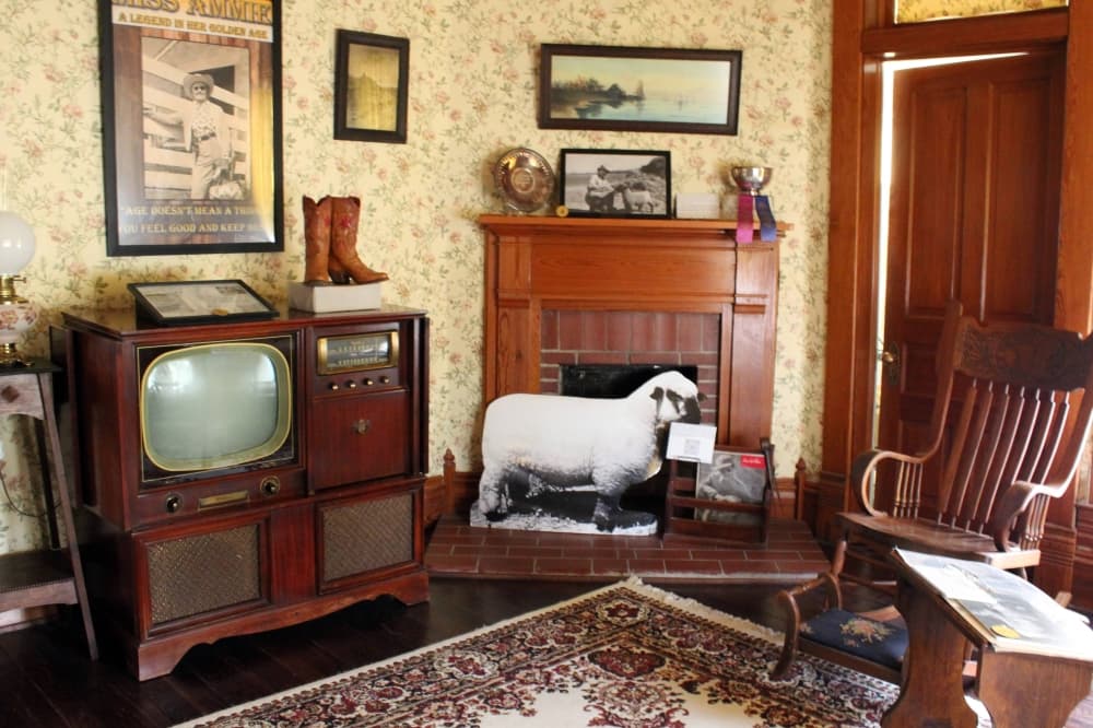 Room with antique furniture like tv and chair. 