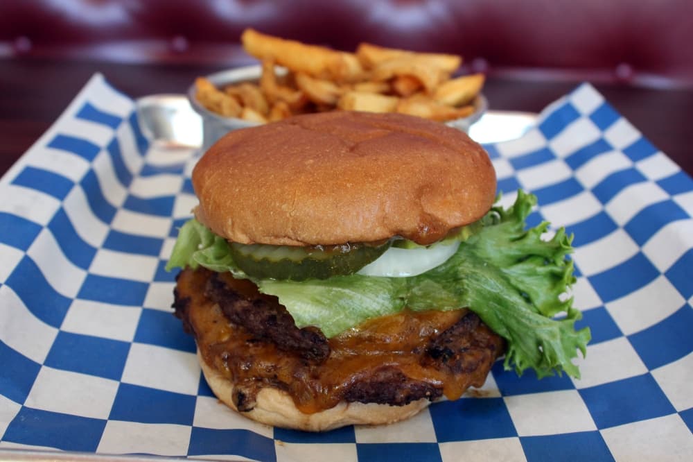 Royale burger ($16) is two smash patties served with house sauce, cheddar cheese, lettuce, tomato, pickle, onion, and thick cut chips. Karen Chaney/Community Impact)