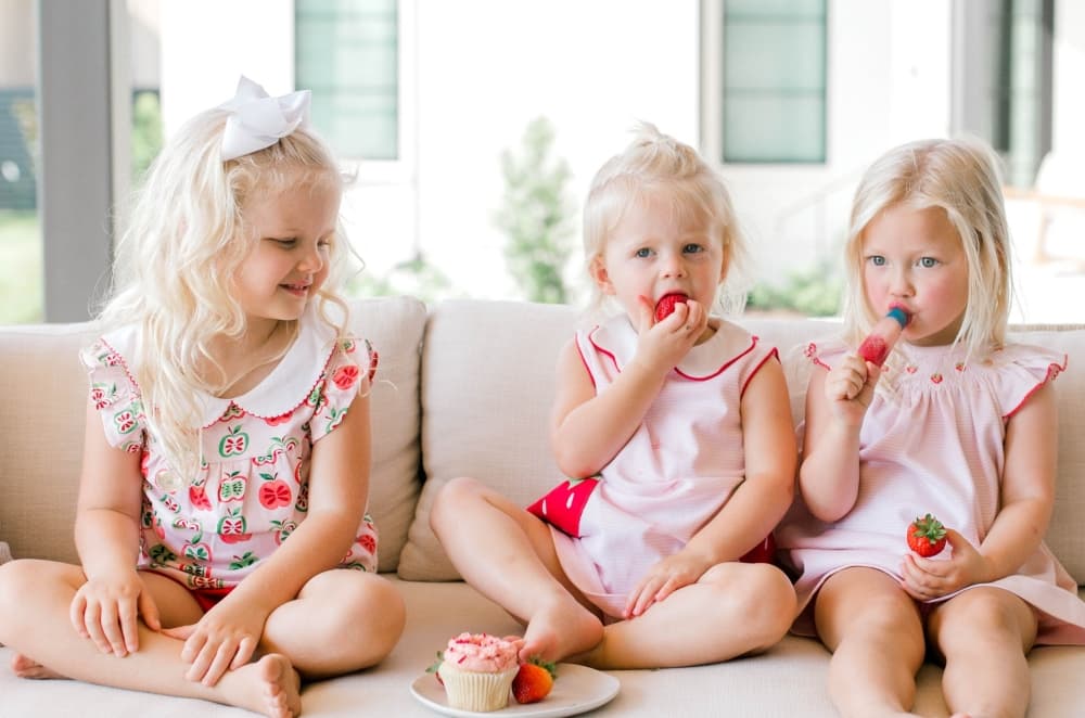 3 kids in monogrammed or designer clothing 