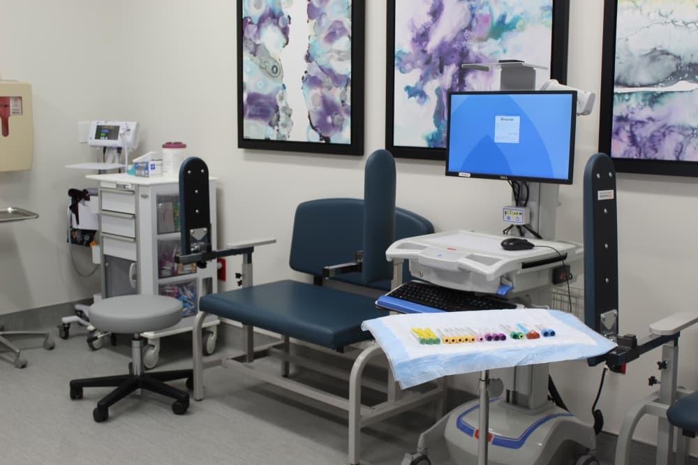 A room with chairs, vitals and a computer screen