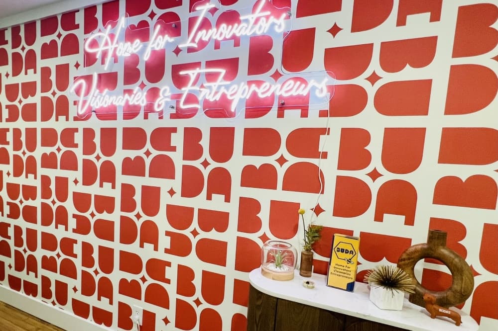 A photo of a wall that has a sign that says Home for Innovators, Visionaries, and Entrepreneurs