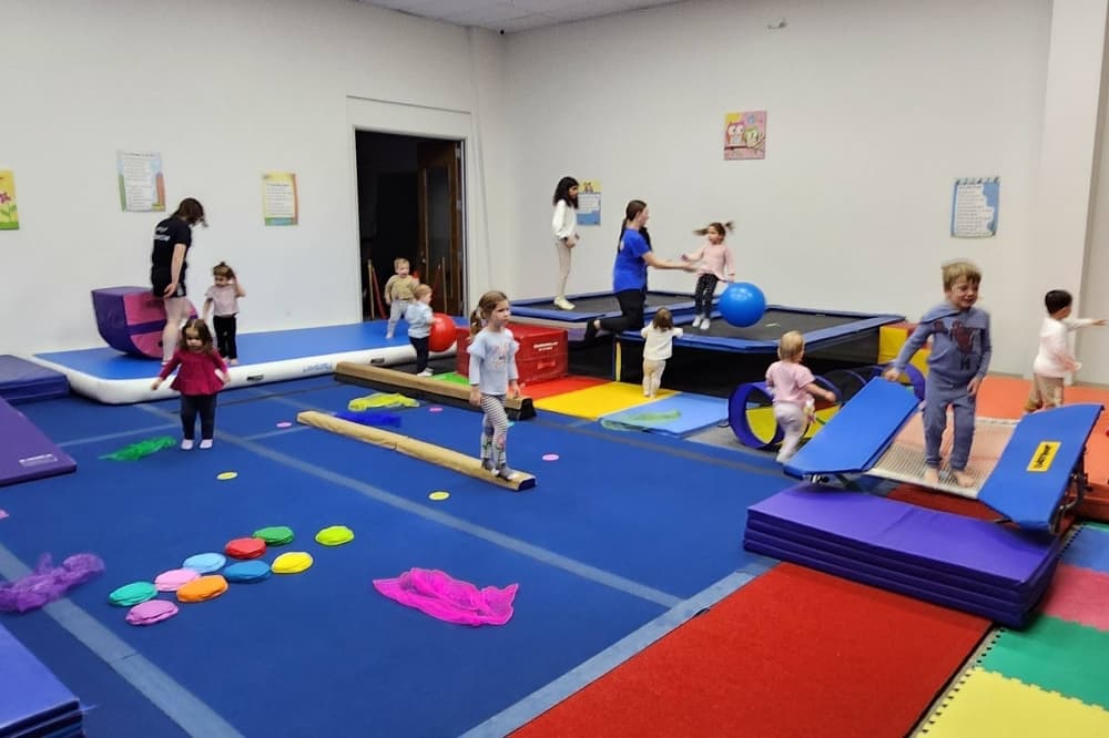 Young children interacting in a gymnastics/tumbling environment. 