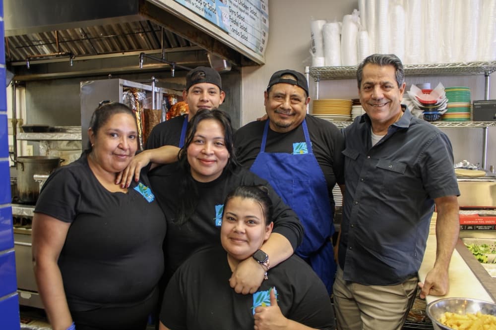 An image of the owner of the business with the staff. 