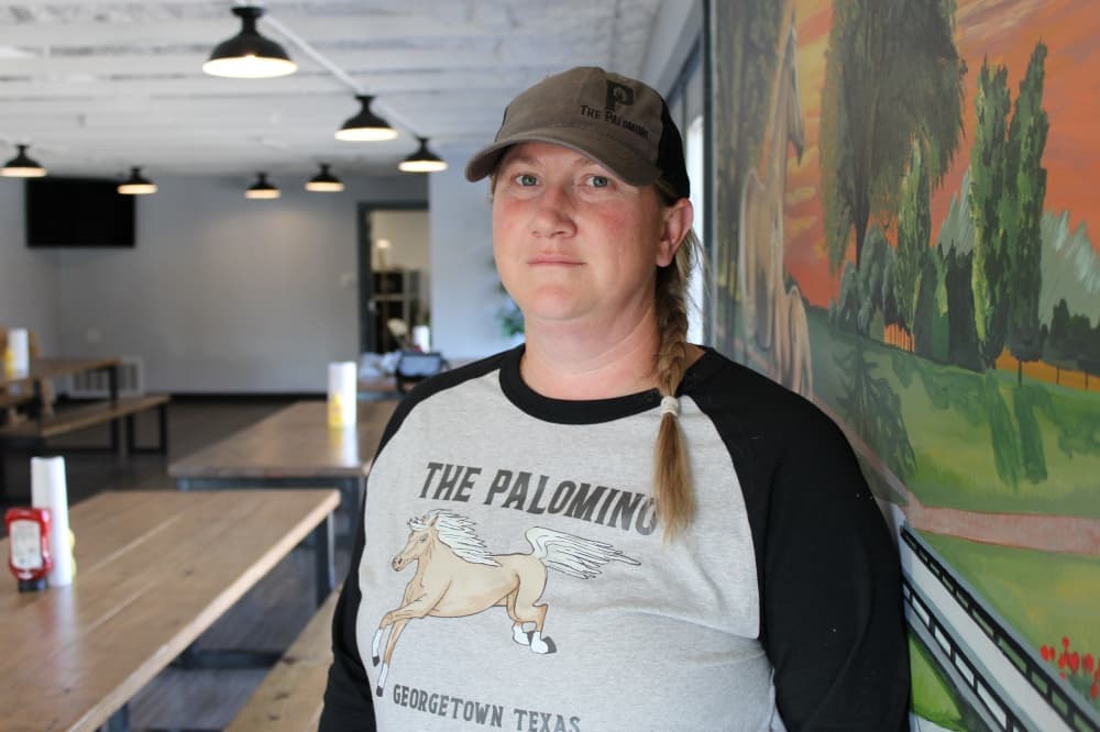 Owner poses inside restaurant. 