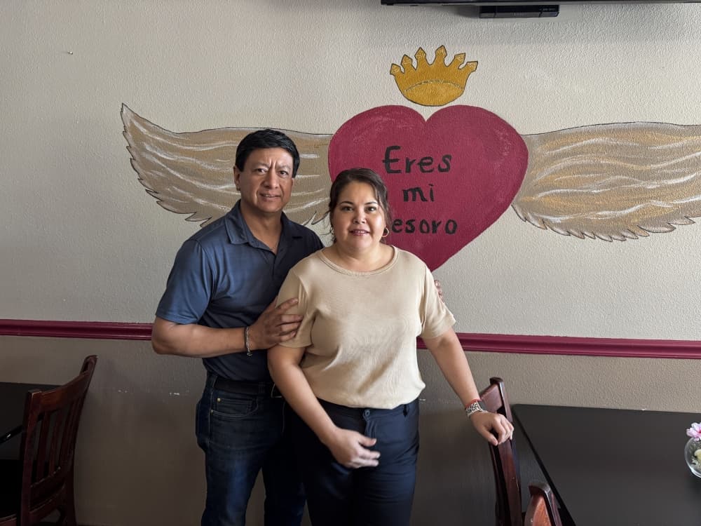 A couple standing in front of a mural.
