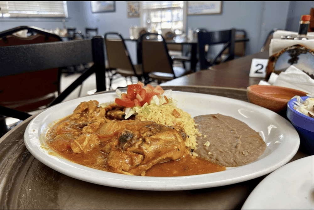 Monterrey Cafe's pollo encebollado ($9.99) is made with chicken and sauteed onions topped with a red chile sauce. It comes with a side of rice, beans and salad. (Thalia Guzman/Community Impact)
