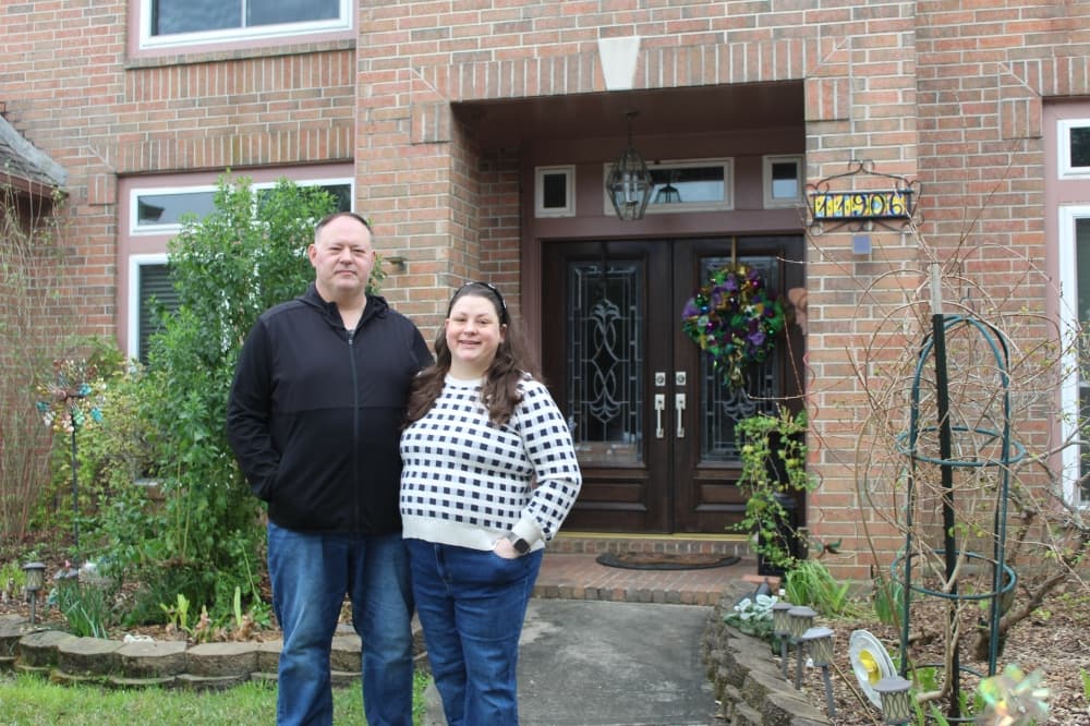 Couple in front of their home