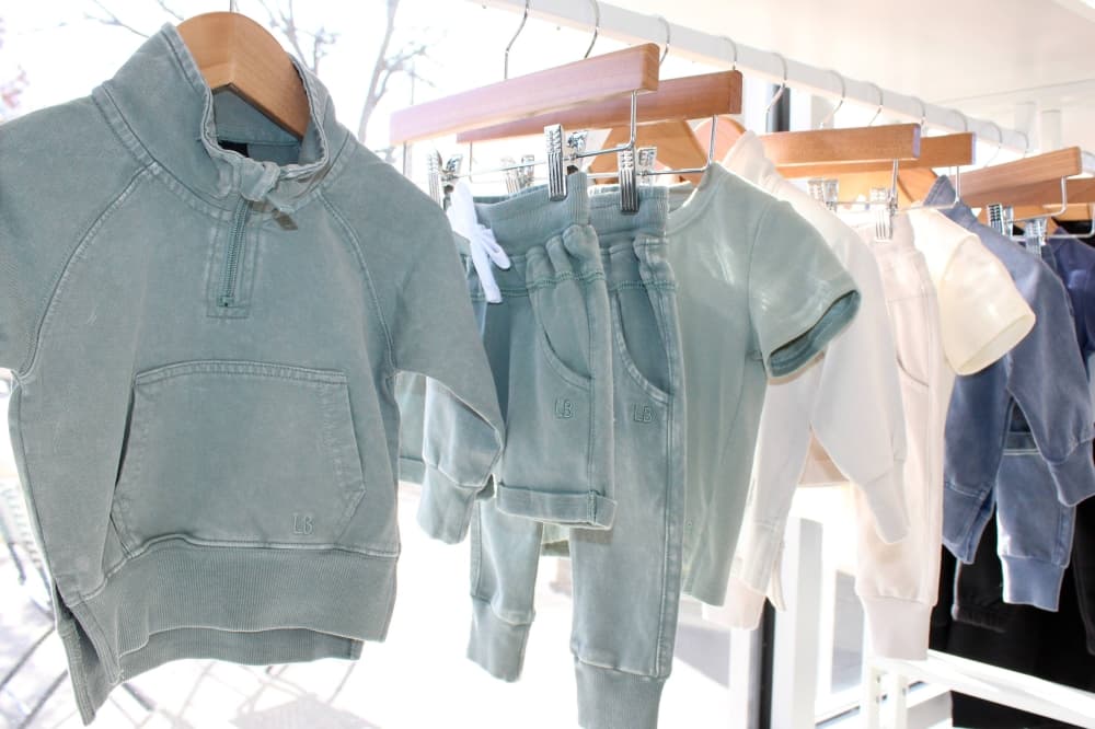 Children's apparel in faded greens and blue and white. 