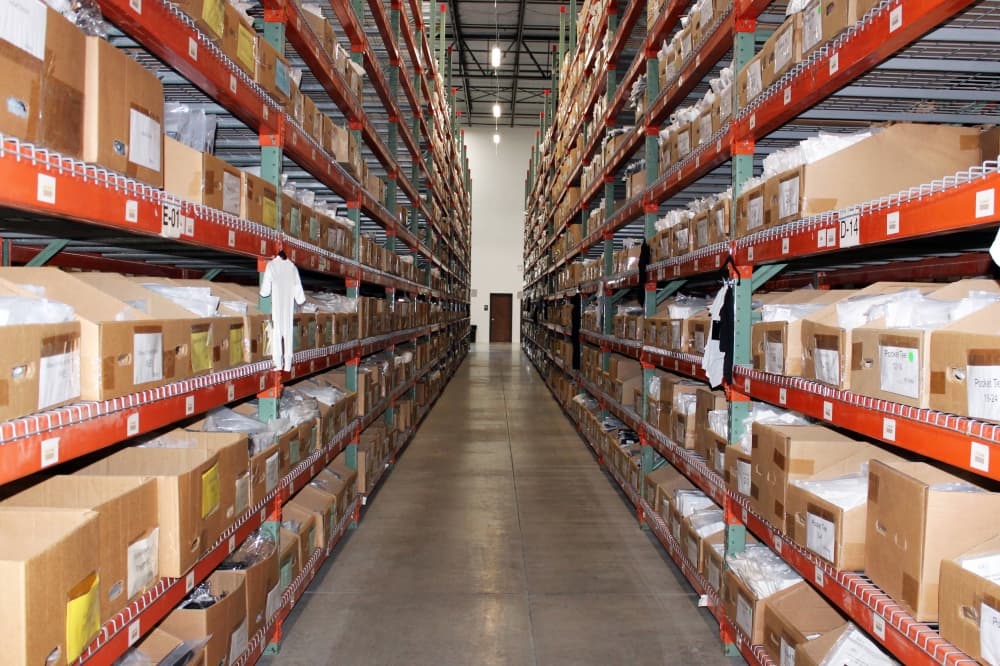 Warehouse shelves with a door at the end of the aisle. 