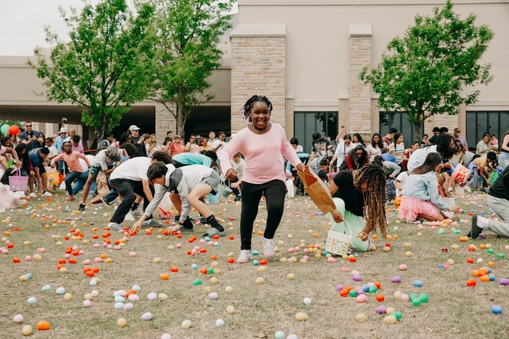 children grab eggs on the ground during an Easter Egg Hunt