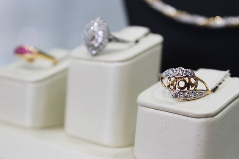Three rings on display platforms. The front ring features the word 'Mom'. 