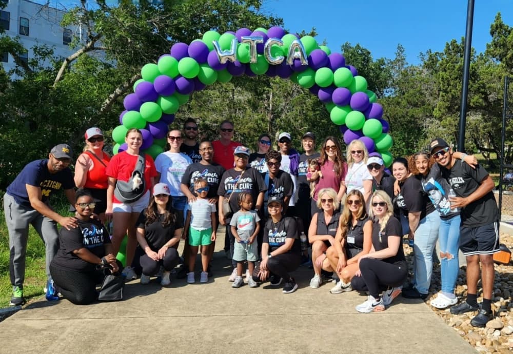 people posing for photo with balloon arch