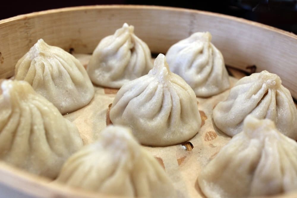 Steamed dumplings in a bamboo dish. 