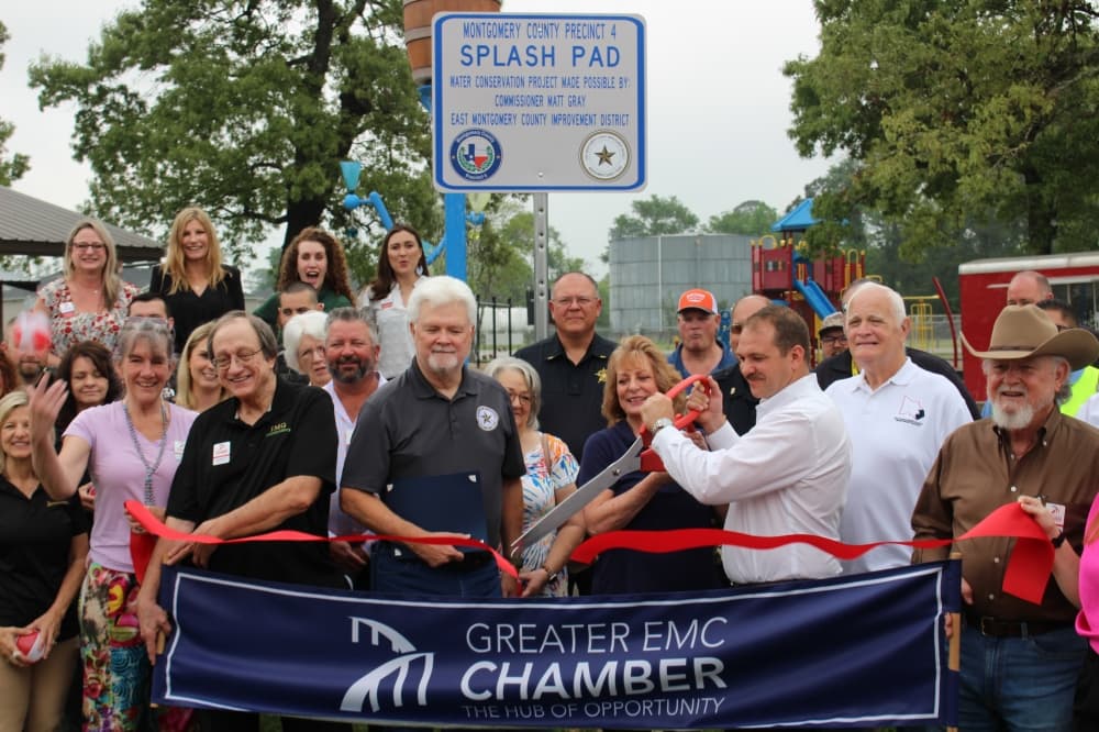 Members of the Precinct 4 Commissioners Office, East Montgomery County Chamber of Commerce and East Montgomery County Improvement District held a ribbon cutting for the new splash pad. (Jessica Shorten/Community Impact)