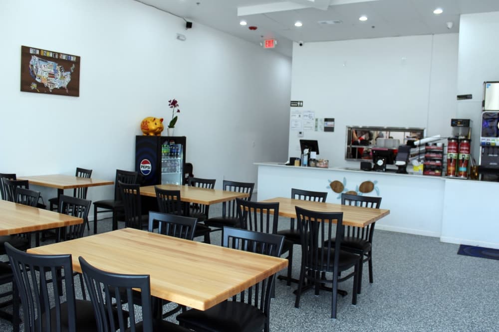 Interior of restaurant with tables and customer service counter. 