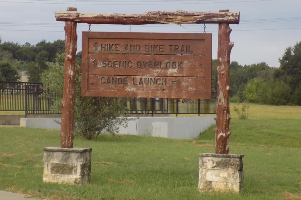 A sign is shown directing to trails, a scenic overlook and canoe launch area.