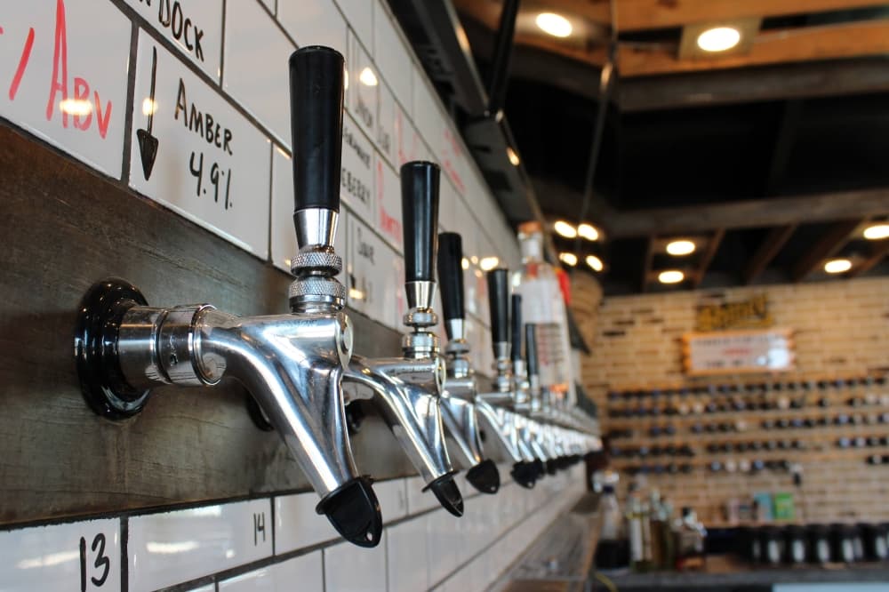Beverage taps with drink names written above them. 
