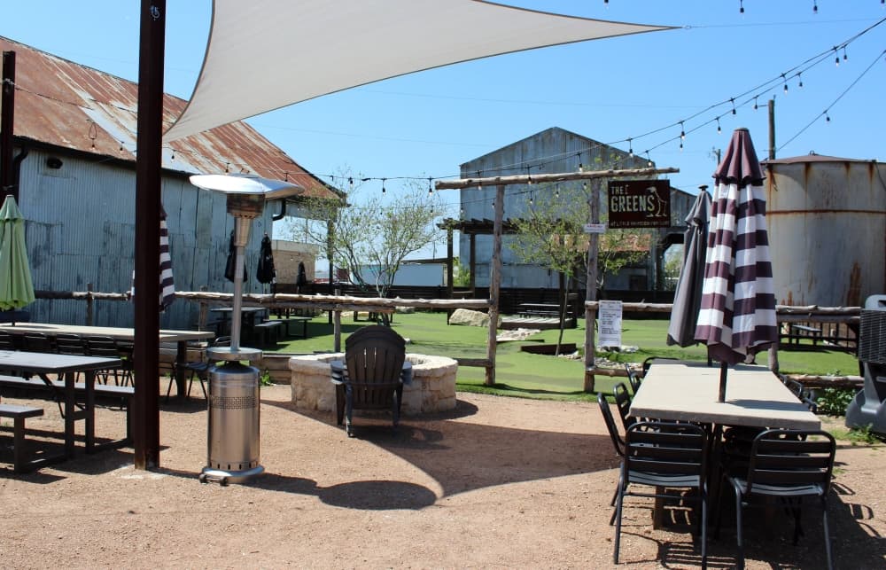 Exterior of business with picnic tables and sun awnings. 