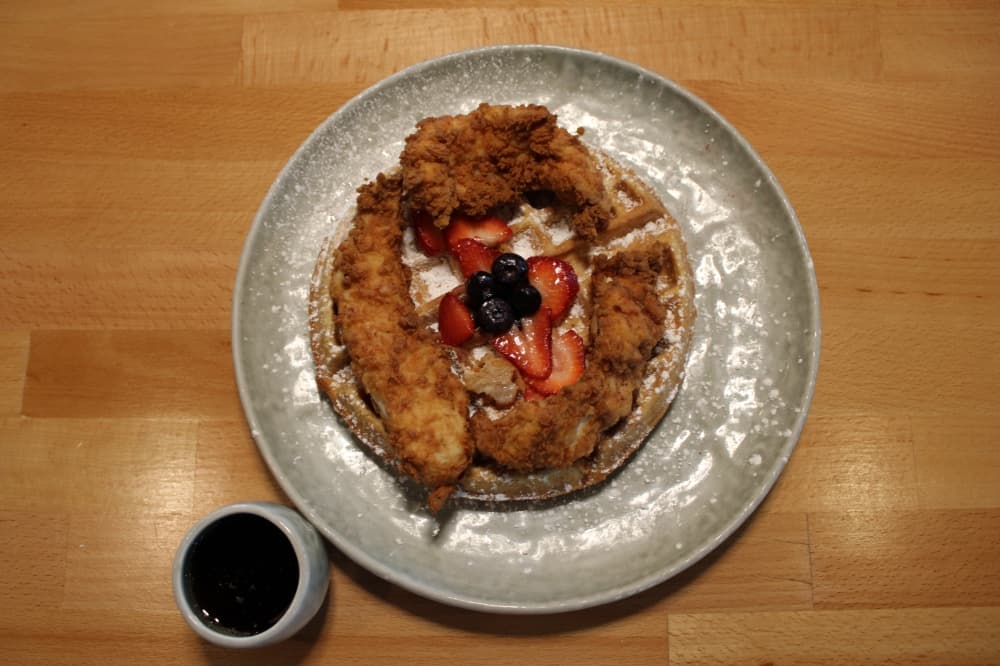 Chicken and waffles ($15.00) includes berries, powdered sugar and hot syrup.