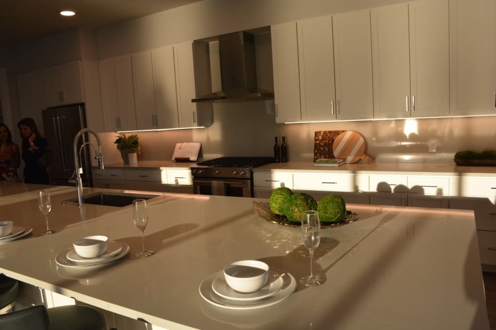 The kitchen includes a large island that doubles as a dining area within a penthouse in Thirty-One Eleven Sunset. 