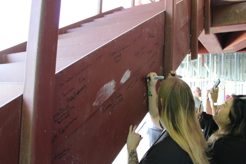 After remarks from officials, county staff who will work in the building were invited to sign a beam on a staircase by the entrance of the future building.
