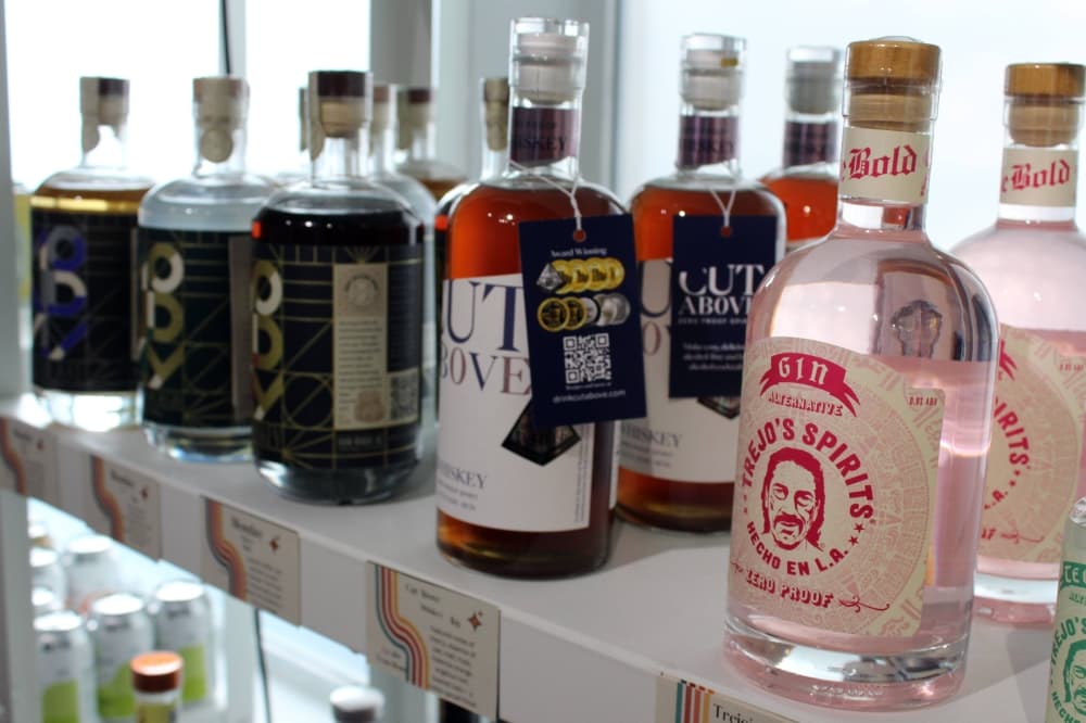 Bottles of liquid lined up on a shelf. 
