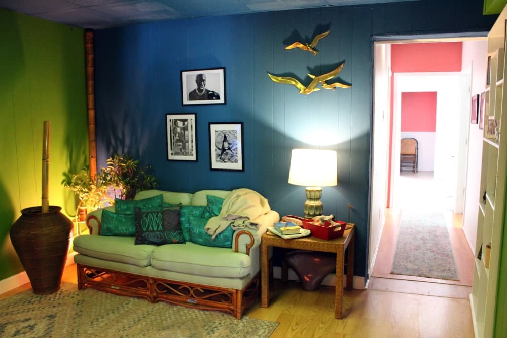Green rattan couch in a aquamarine painted room. 