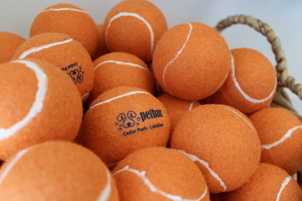 An image of tennis balls with the brand name. 