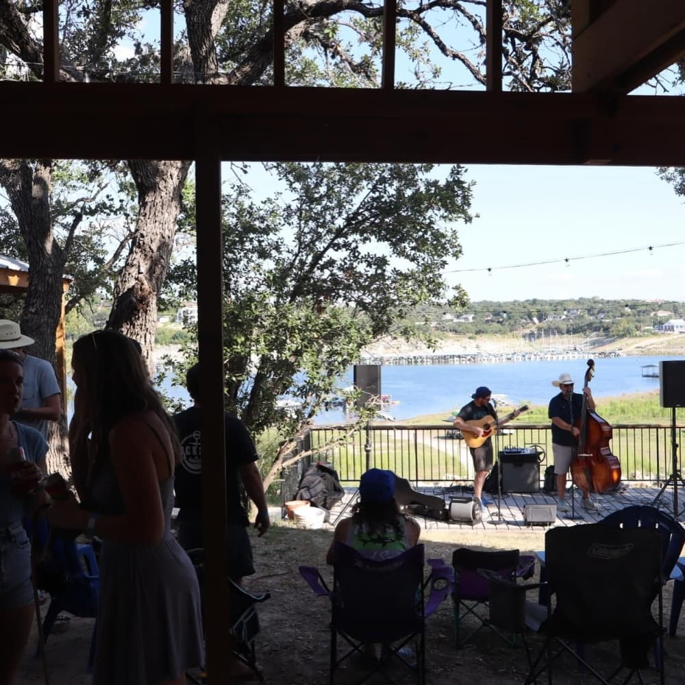 Musicians playing with Lake Travis in the background