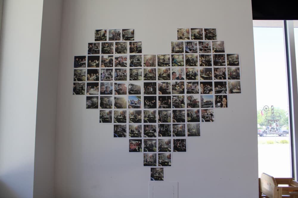 An image of a heart wall shaped by photos with customers. 