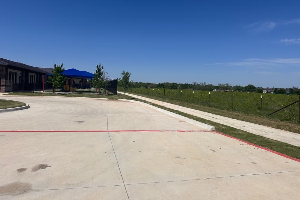A photo of open land behind a building where the development is planned to go. 
