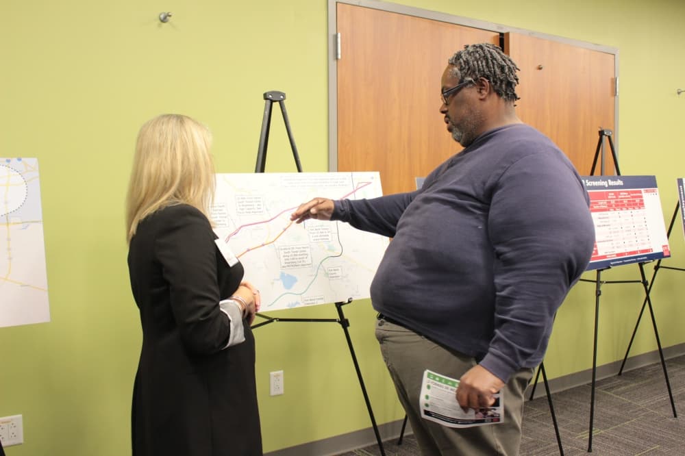 Transit Planning Lead Laura Grams visits with community members during the April 23 public meeting. (Aubrey Vogel/Community Impact)