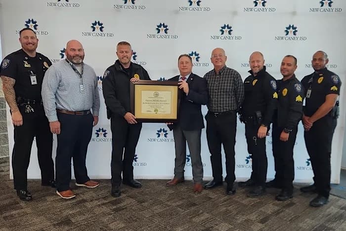 New Caney ISD police department member posed with an award