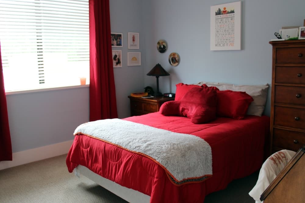Bedroom decorated with red and white design elements. 