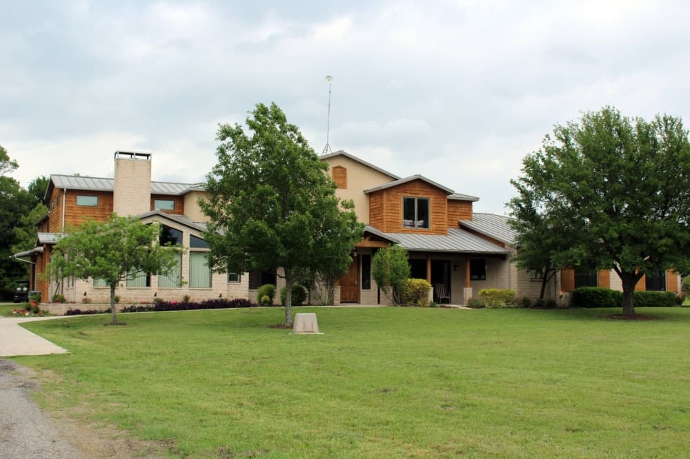 Exterior of a house with trees in front. 