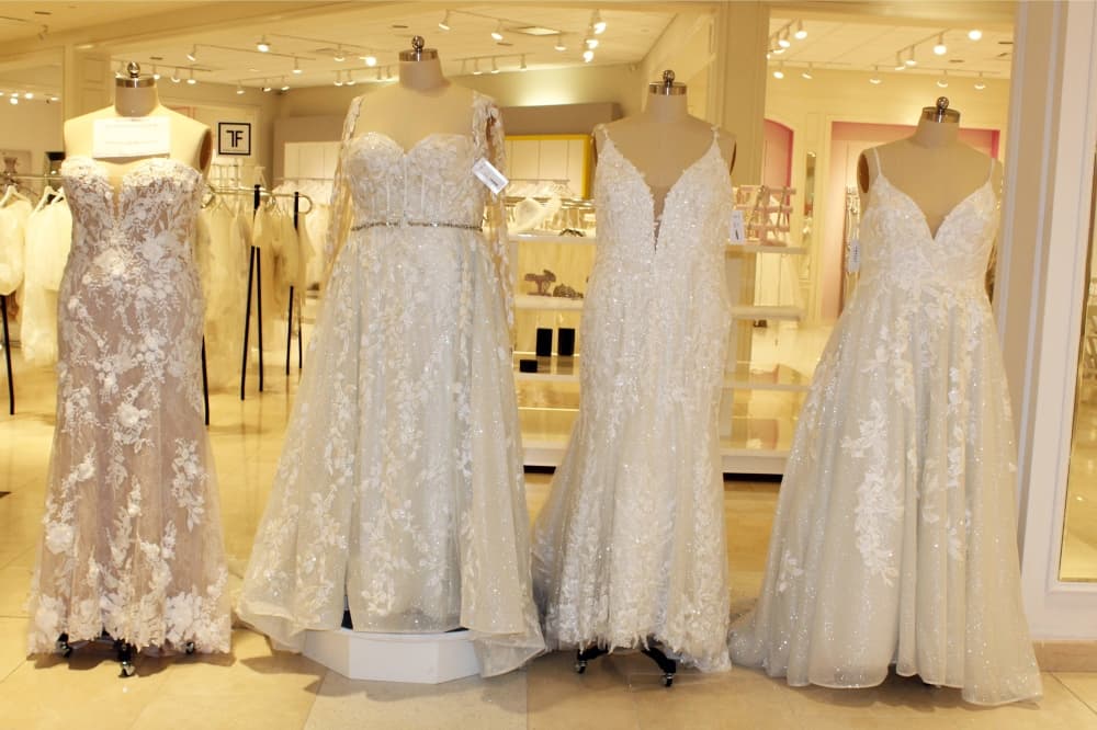 Four wedding dresses on mannequins. 