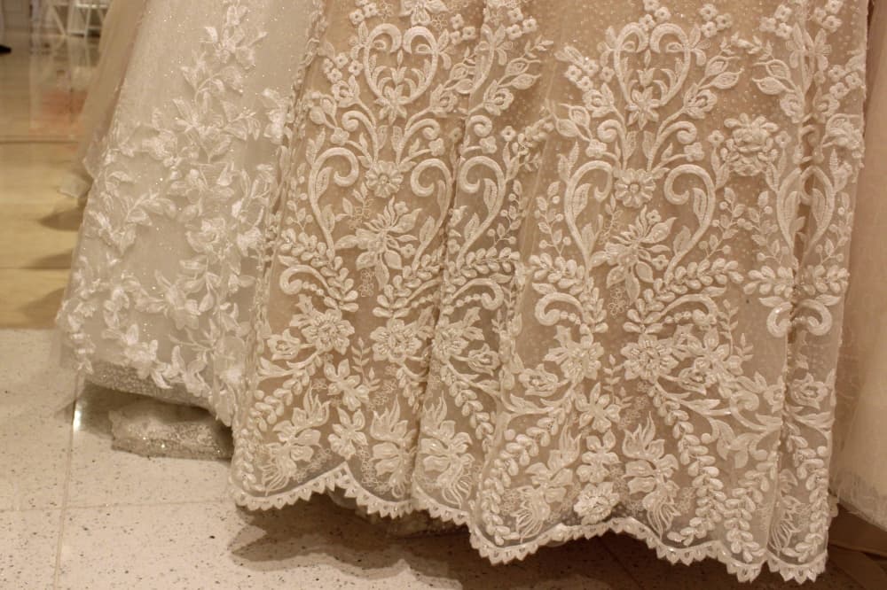 Bottom of wedding dresses featuring extensive embroidery. 