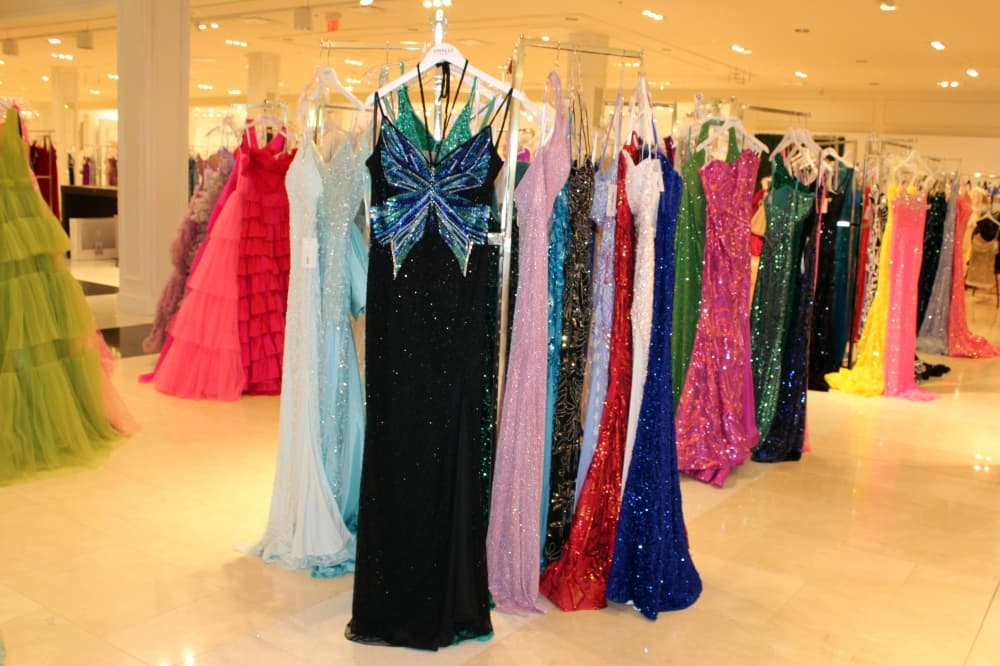 Sequined dresses hanging on racks in a store. 