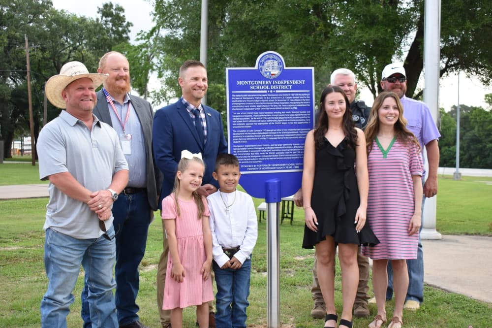 Montgomery County community members stand around a new historical marker for the county on April 30 after it was unveiled. The marker commemorates 100 years of MISD. (Julianna Washburn/Community Impact)