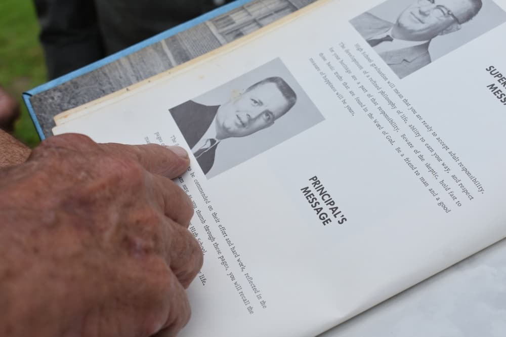 A former MISD students points at a page in his Montgomery High School yearbook from 1960. (Julianna Washburn/Community Impact)