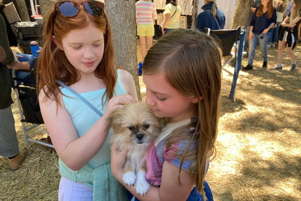 Two girls petting a dog