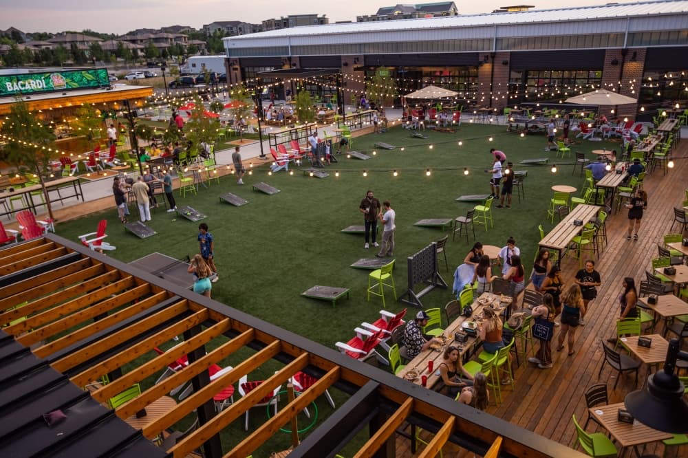 Image of a Chicken N Pickle outdoor space with people pictured