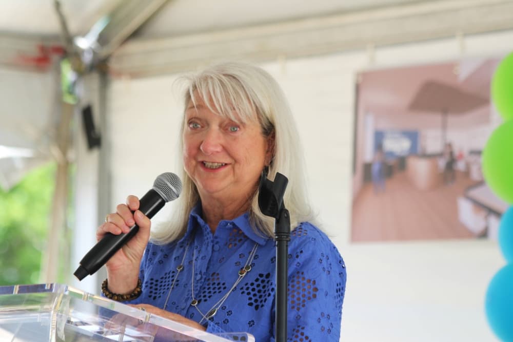 Female speaking into a microphone at a podium. 