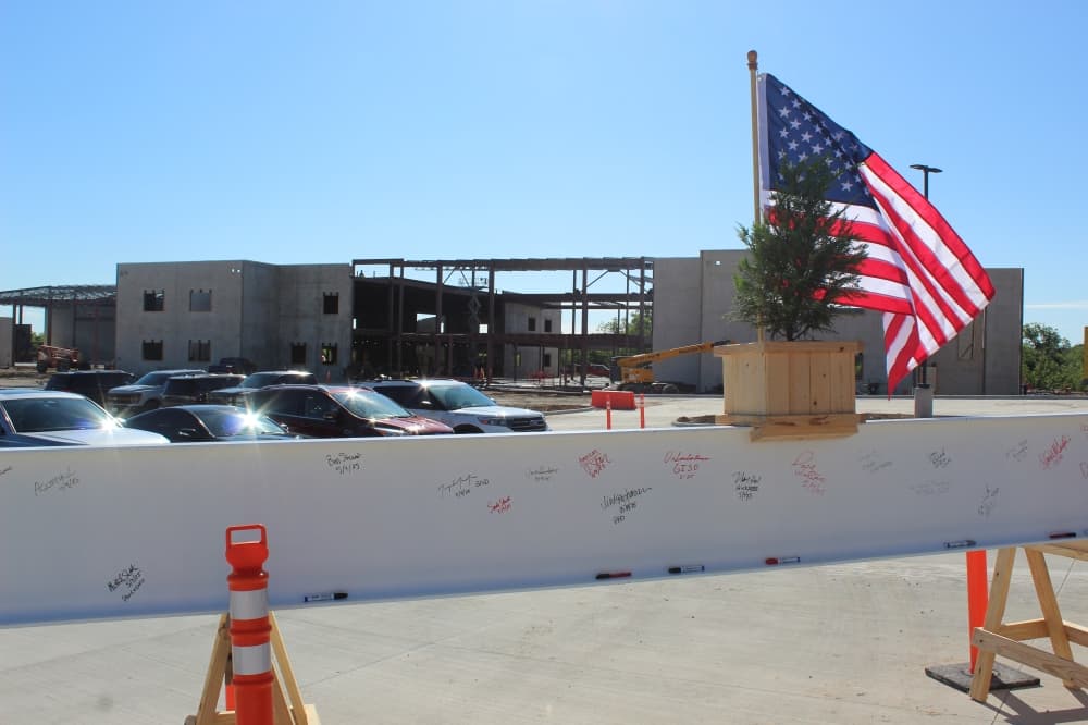 A beam with signatures in front of an elementary school under construction