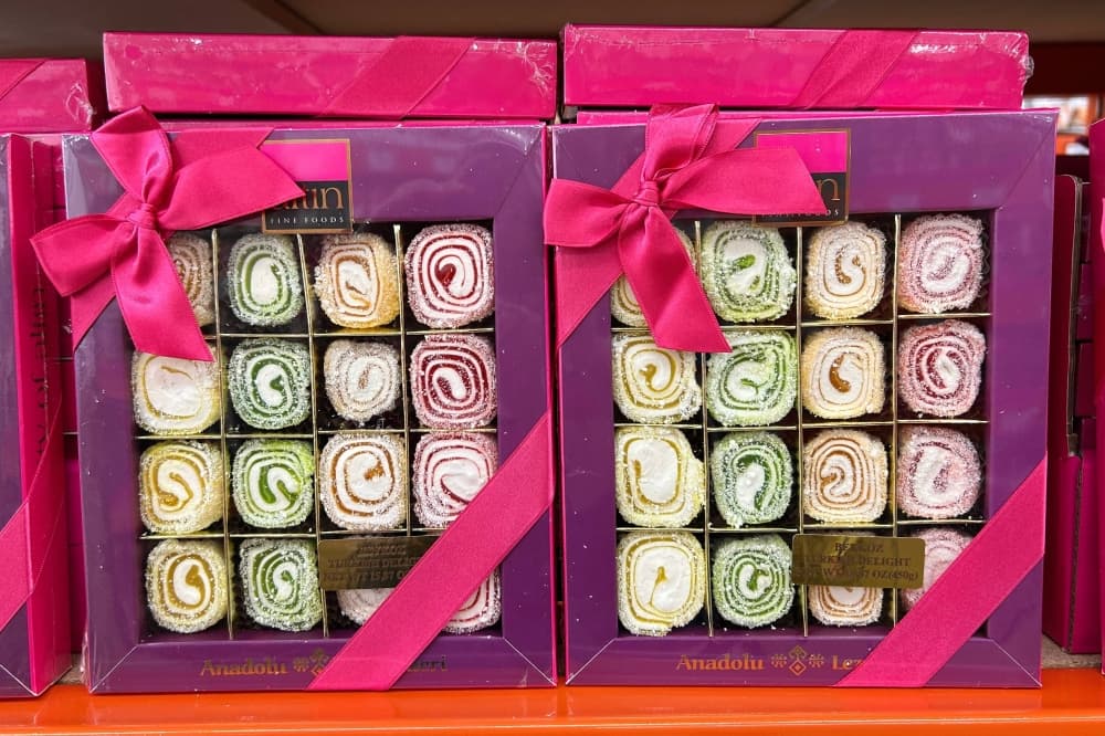 Fancy purple boxes holding rows of sweet treats. 